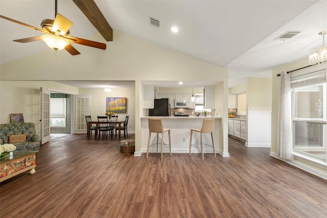 kitchen featuring white cabinetry, kitchen peninsula, black fridge, dark wood-type flooring, and lofted ceiling with beams