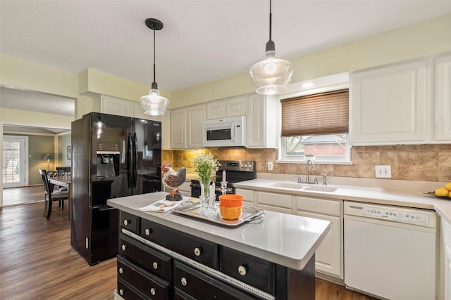 kitchen with a center island, white appliances, hanging light fixtures, sink, and white cabinets