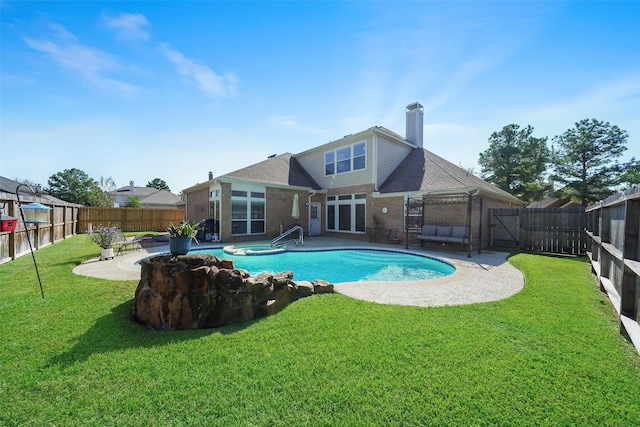 back of property with a fenced in pool, a patio, and a yard