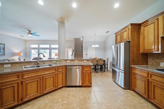 kitchen featuring pendant lighting, appliances with stainless steel finishes, sink, light tile patterned floors, and decorative backsplash