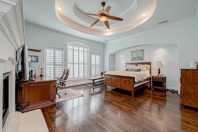 bedroom with dark hardwood / wood-style flooring, crown molding, and a raised ceiling