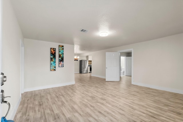 interior space featuring light wood-type flooring and an inviting chandelier