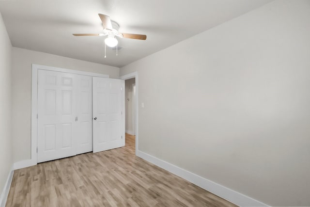 unfurnished bedroom featuring ceiling fan, a closet, and light hardwood / wood-style flooring