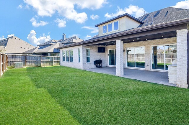 rear view of house featuring a yard and a patio