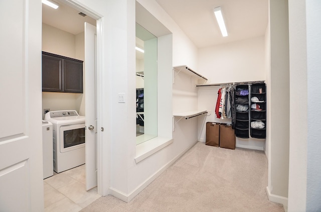 laundry area featuring light carpet, cabinets, and washing machine and clothes dryer