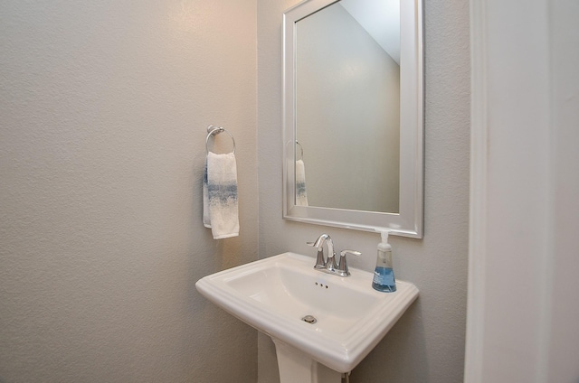 bathroom with a textured wall and a sink