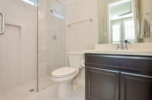 bathroom with tile patterned flooring, toilet, vanity, and a healthy amount of sunlight