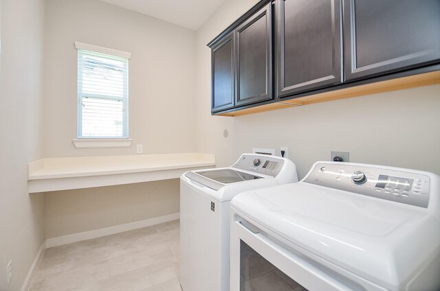 clothes washing area with washer and clothes dryer and cabinets