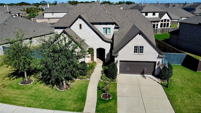 french provincial home with a garage and a front yard