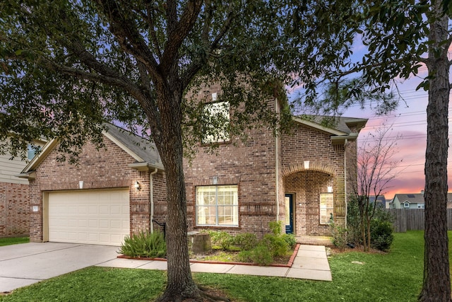 front facade featuring a garage and a yard