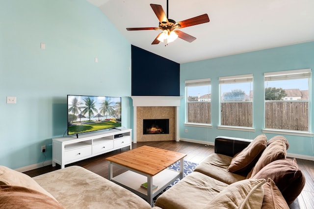 living room featuring vaulted ceiling, ceiling fan, hardwood / wood-style floors, and a fireplace