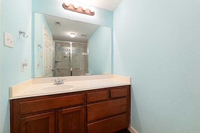 bathroom with vanity and a shower with shower door