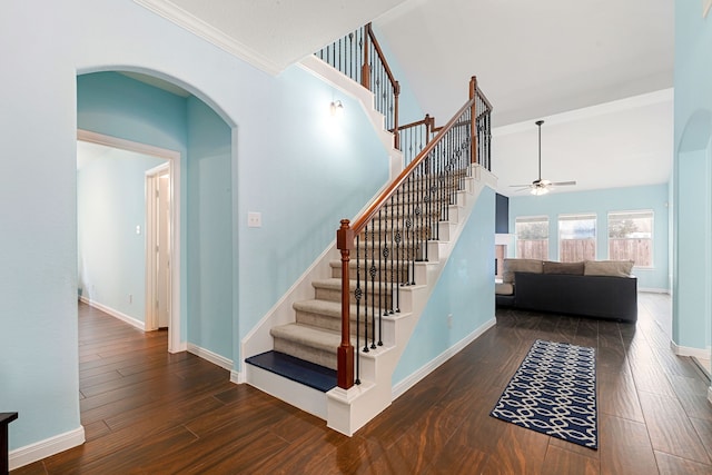 staircase with ceiling fan, crown molding, and wood-type flooring