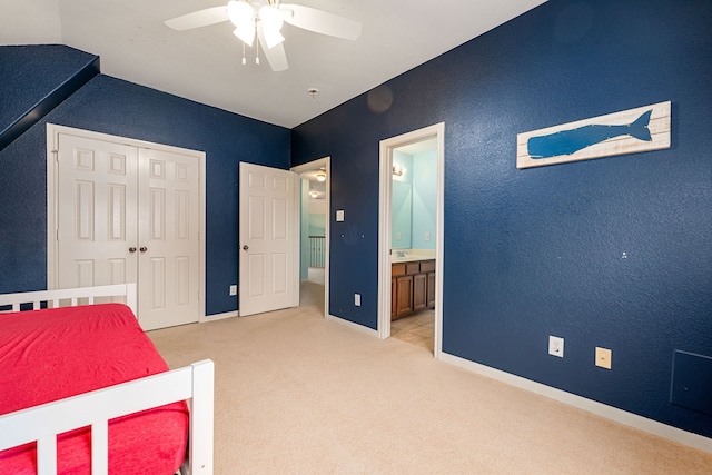 carpeted bedroom featuring ceiling fan, lofted ceiling, a closet, and ensuite bath