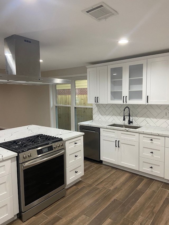 kitchen with white cabinetry, dishwasher, island exhaust hood, and stainless steel gas range oven