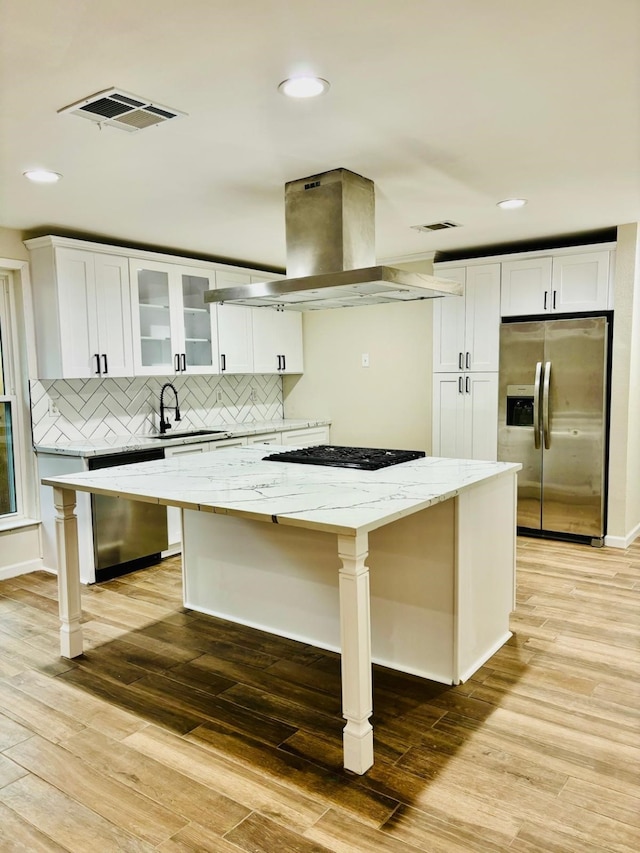 kitchen featuring white cabinets, island range hood, a center island, and stainless steel appliances