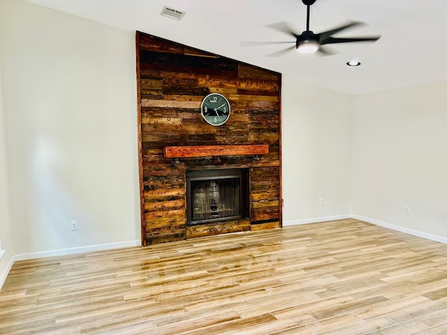 unfurnished living room with a fireplace, light wood-type flooring, vaulted ceiling, and ceiling fan