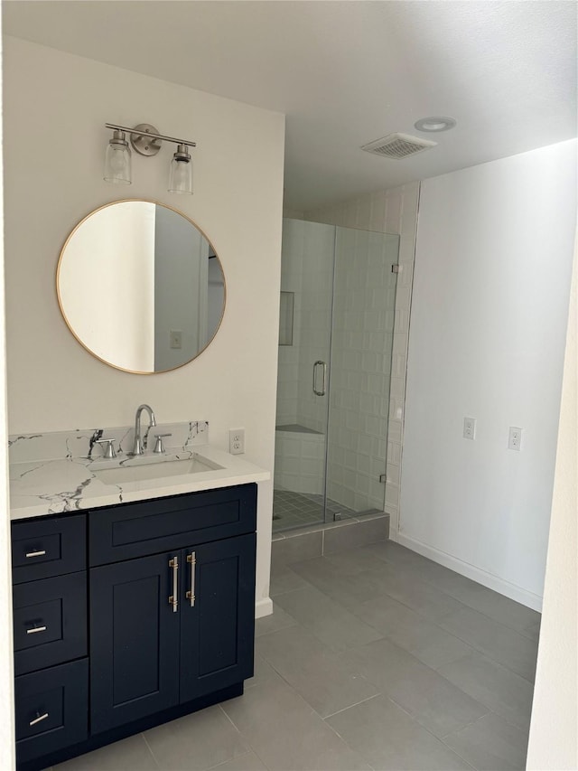 bathroom with a shower with door, tile patterned floors, and vanity