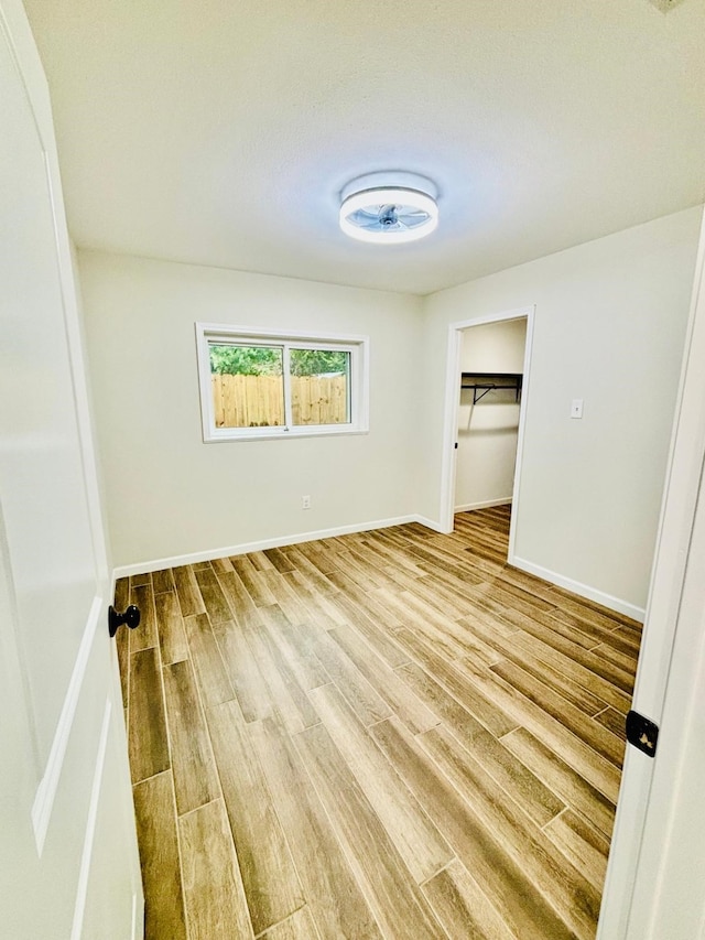 unfurnished bedroom featuring hardwood / wood-style flooring, a closet, and a spacious closet