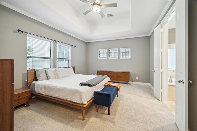 bedroom with ceiling fan, multiple windows, light colored carpet, and a tray ceiling