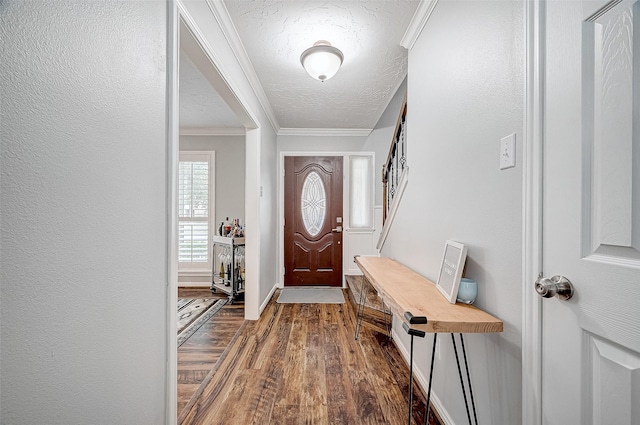 entryway featuring ornamental molding, dark wood-type flooring, and a textured ceiling