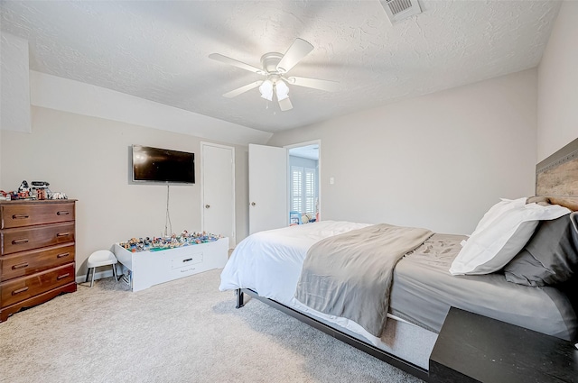 carpeted bedroom featuring a textured ceiling and ceiling fan