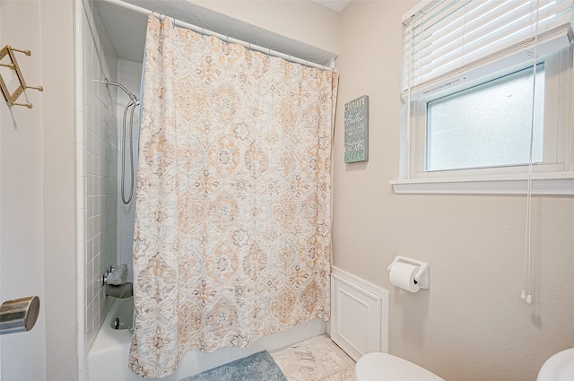 bathroom featuring toilet and shower / tub combo with curtain