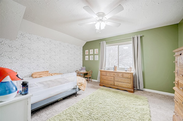 bedroom with ceiling fan, a textured ceiling, light carpet, and lofted ceiling