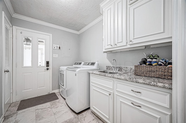 laundry area featuring a textured ceiling, washing machine and dryer, cabinets, sink, and crown molding