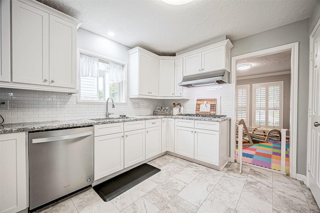 kitchen with a textured ceiling, white cabinets, stainless steel appliances, sink, and light stone counters