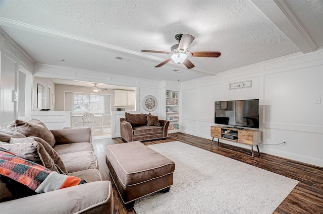 living room with built in shelves, ceiling fan, a textured ceiling, and dark hardwood / wood-style flooring