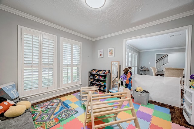 playroom featuring a textured ceiling and ornamental molding