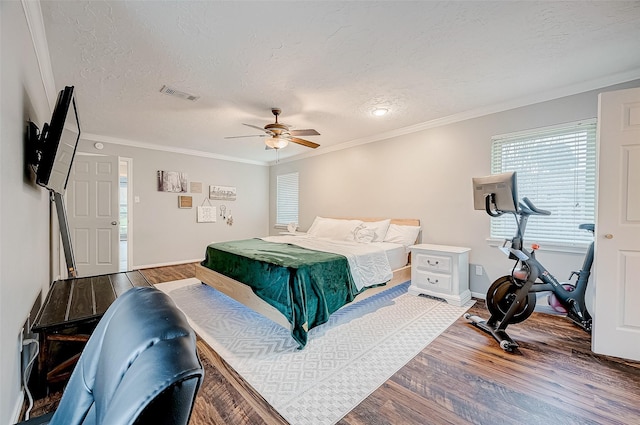 bedroom with ceiling fan, wood-type flooring, crown molding, and a textured ceiling