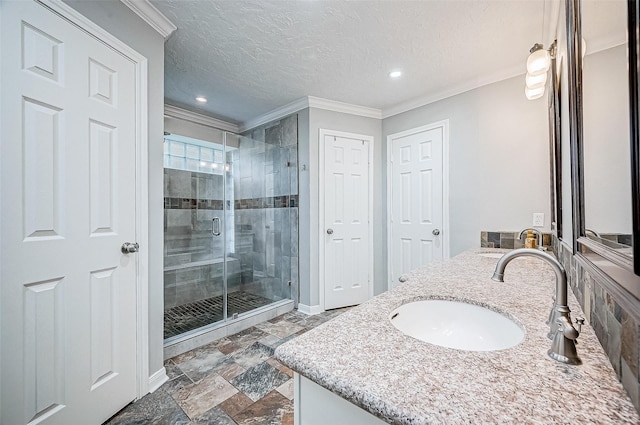 bathroom with crown molding, a textured ceiling, a shower with shower door, and vanity