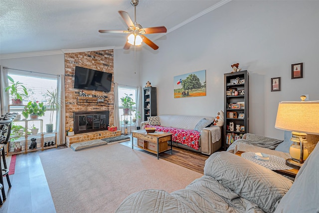 living room featuring wood-type flooring, ceiling fan, high vaulted ceiling, ornamental molding, and a brick fireplace