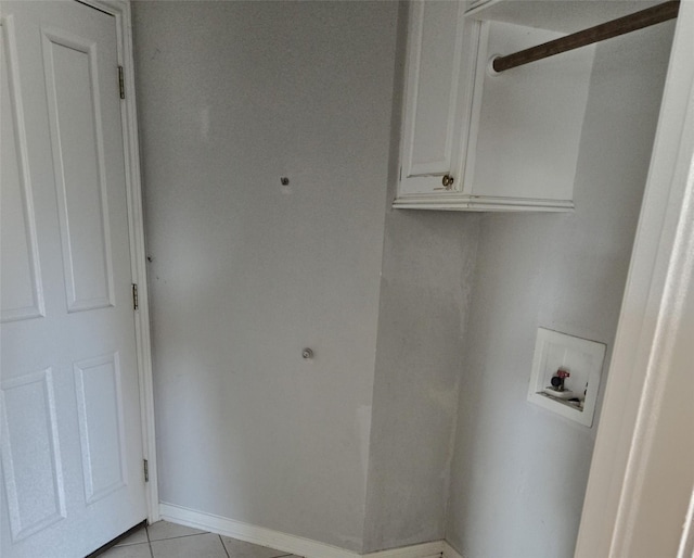 washroom with hookup for a washing machine, cabinets, and light tile patterned floors