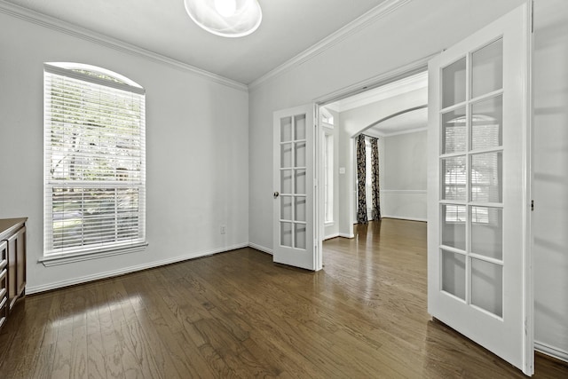 empty room featuring crown molding, dark hardwood / wood-style flooring, and french doors