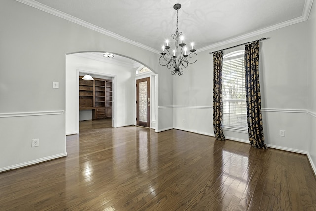 unfurnished room featuring crown molding, dark wood-type flooring, and a chandelier