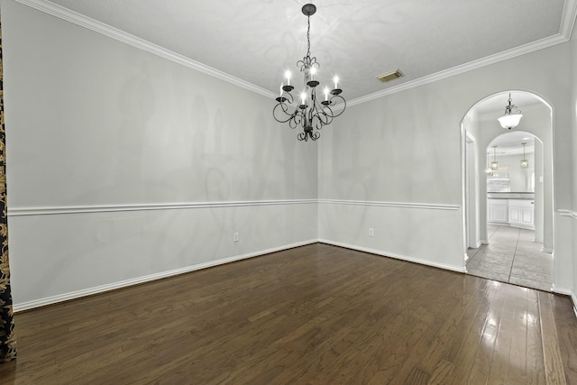 unfurnished room featuring hardwood / wood-style flooring, a chandelier, and crown molding