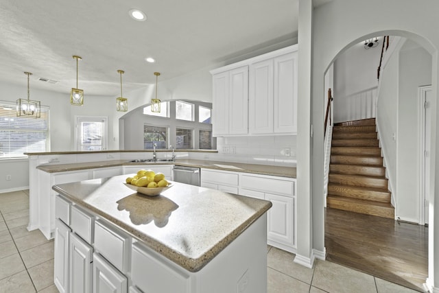 kitchen featuring a center island, stainless steel dishwasher, and light tile patterned flooring