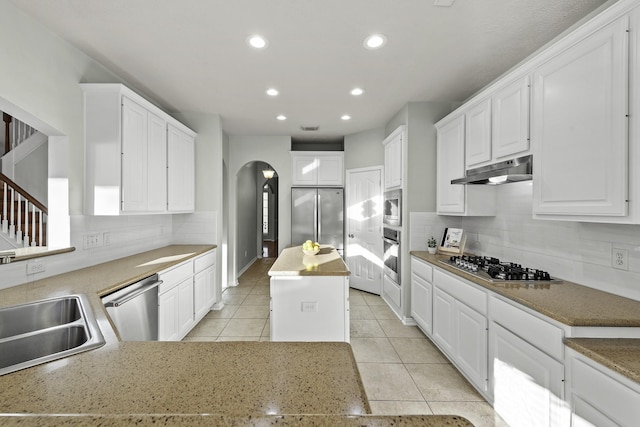 kitchen featuring white cabinetry, appliances with stainless steel finishes, a center island, and tasteful backsplash