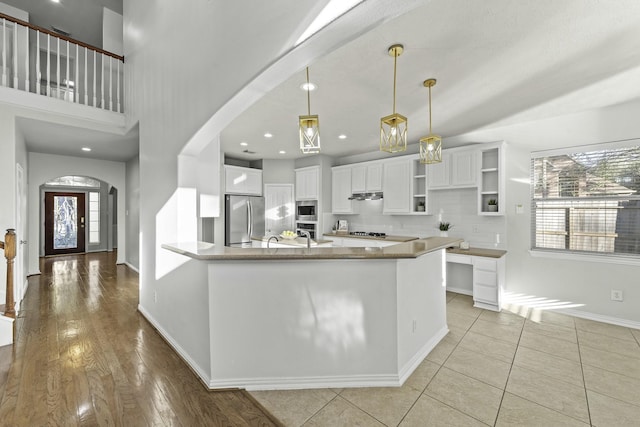 kitchen with white cabinets, a healthy amount of sunlight, appliances with stainless steel finishes, and tasteful backsplash