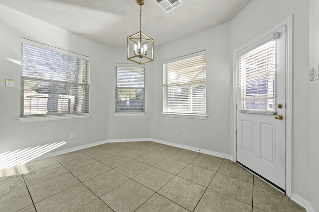 unfurnished dining area with light tile patterned floors and a notable chandelier