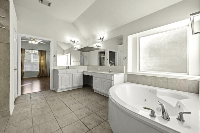 bathroom featuring ceiling fan, tile patterned flooring, a washtub, vanity, and vaulted ceiling