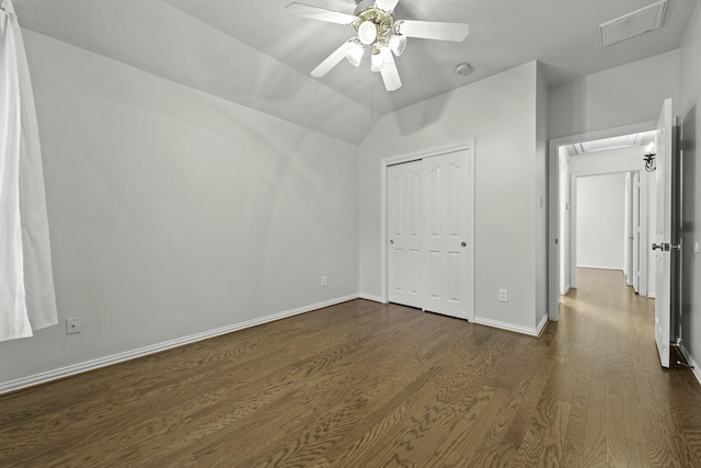 unfurnished bedroom with a closet, vaulted ceiling, ceiling fan, and dark hardwood / wood-style flooring