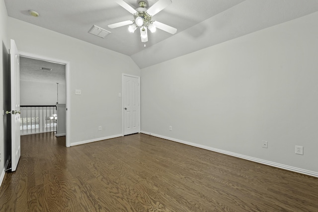 spare room with ceiling fan, vaulted ceiling, dark hardwood / wood-style floors, and a textured ceiling