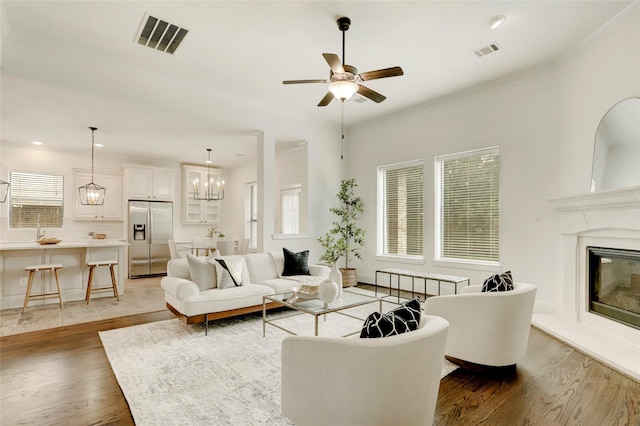 living room featuring ceiling fan with notable chandelier and dark hardwood / wood-style flooring