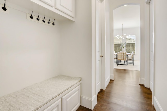 mudroom with dark wood-type flooring and an inviting chandelier