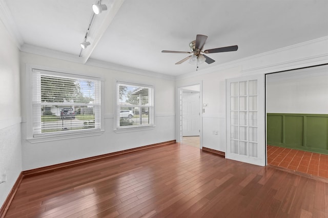 unfurnished bedroom with ceiling fan, rail lighting, crown molding, and wood-type flooring