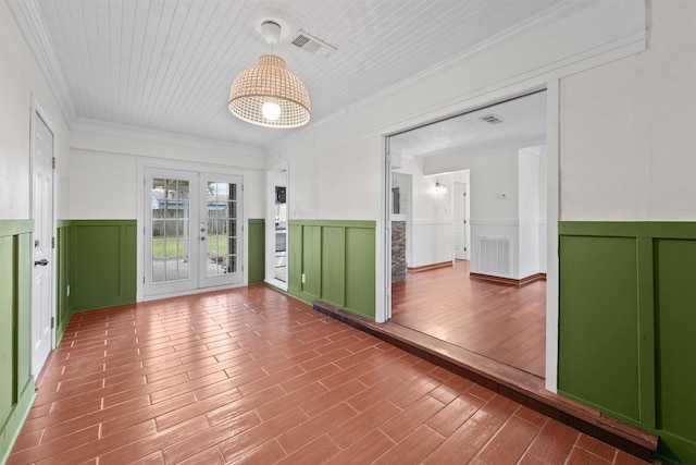 empty room featuring french doors and ornamental molding